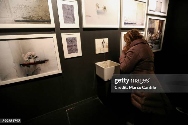 Woman looks inside a typical sink that could be found in psychiatric hospitals, in the museum of madness.