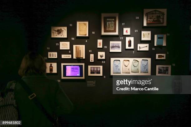 Woman looks at a series of objects that belonged to madmen locked up in mental hospitals, in the museum of madness.