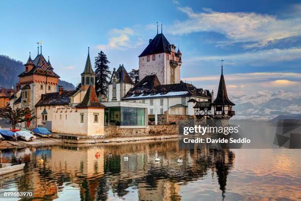 view of the oberhofen castle reflecting in lake thun - oberhoffen castle stock pictures, royalty-free photos & images