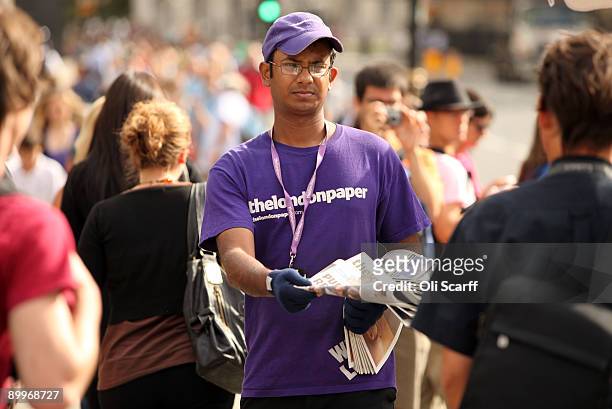 Man hands out copies of The London Paper, a free evening newspaper owned by News International, in front of the Houses of Parliament on August 20,...