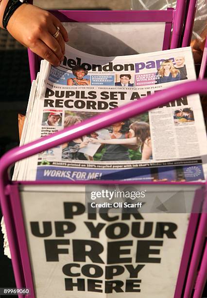 Member of the public picks up a copy of The London Paper, a free evening newspaper owned by News International, in front of the Houses of Parliament...