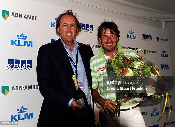 Robert-Jan Derksen of The Netherlands is presented with flowers and champagne for his hole in one on the 11th hole by tournament director Dann...