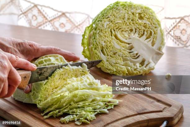 cabbage being sliced with old knife - cappuccio stock-fotos und bilder