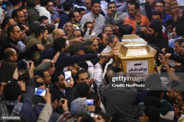 People react around a casket of a female victim during the funeral of victims of an attack, at a church in the working-class suburb of Helwan, Cairo,...