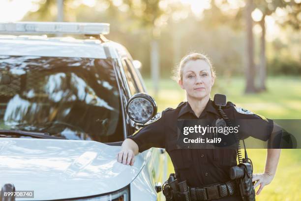 femme policier debout à côté de la voiture de police squad - cop car photos et images de collection