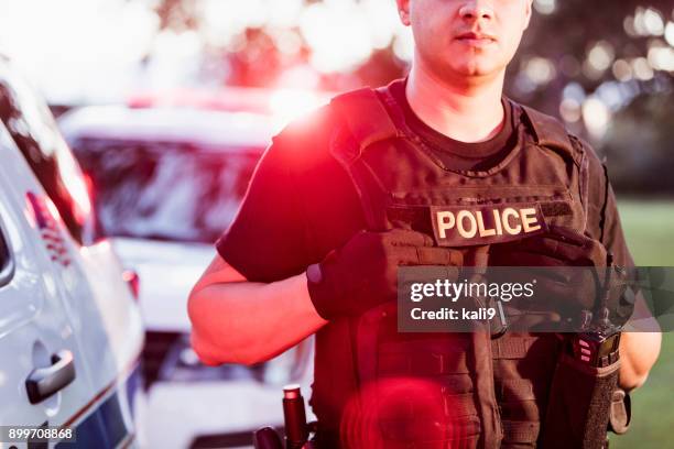 hispanic police officer wearing bulletproof vest - bulletproof stock pictures, royalty-free photos & images