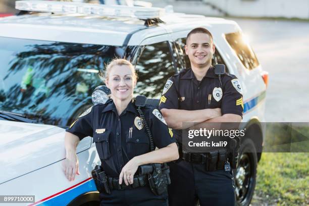 policewoman and partner next to squad car - police officer smiling stock pictures, royalty-free photos & images