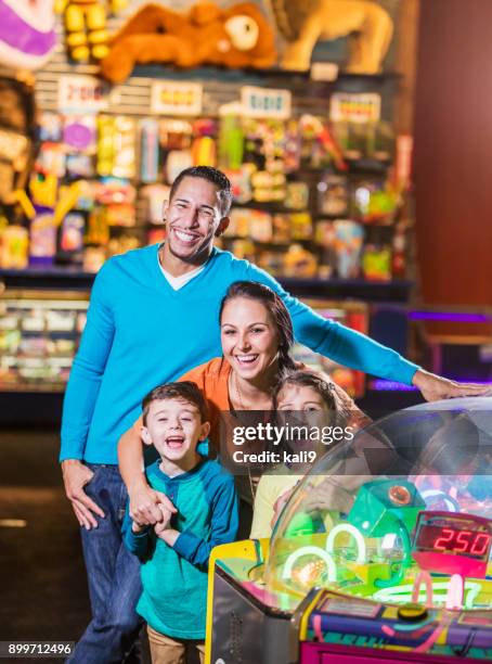 family with two children in amusement arcade - arcade stock pictures, royalty-free photos & images