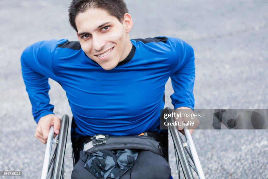 Young man, amputee in wheelchair, smiling at camera