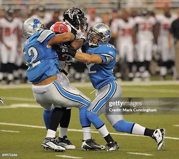 Darnell Bing and Calvin Lowry of the Detroit Lions tackle running back Thomas Brown of the Atlanta Falcons during the game at Ford Field on August...