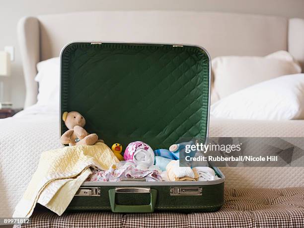 suitcase sitting open on a bed - open travel bag stock-fotos und bilder