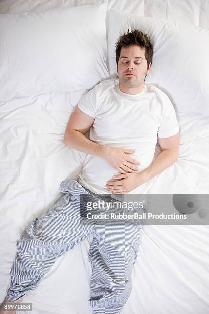 man in bed - above view of man sleeping on bed stock-fotos und bilder