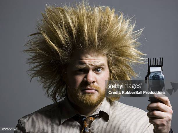 man with crazy hair holding hair clippers - hair standing on end stock pictures, royalty-free photos & images