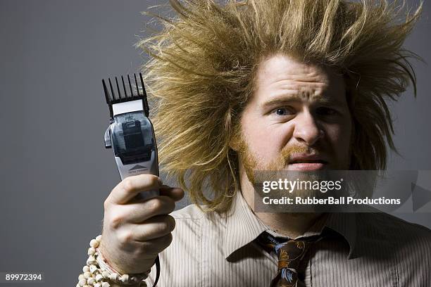 man with crazy hair holding hair clippers - hair standing on end stock pictures, royalty-free photos & images