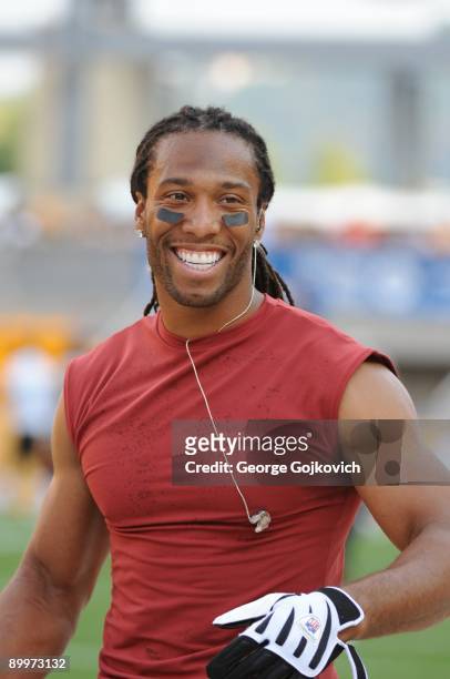 Wide receiver Larry Fitzgerald of the Arizona Cardinals smiles as he looks on from the field during pregame warmup before a preseason game against...
