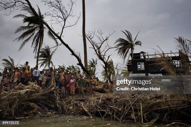 Villagers stand on the riverbank on May 10, 2008 in the village of Kyaun Da Min a few hours south of Pyapon, Myanmar. On May 2 2008 Myanmar was hit...