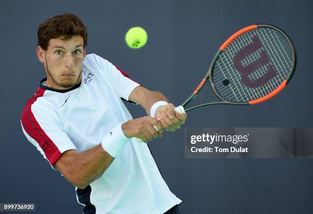Pablo Carreno Busta of Spain plays a backhand during his match against Dominic Thiem of Austria on day three of the Mubadala World Tennis...