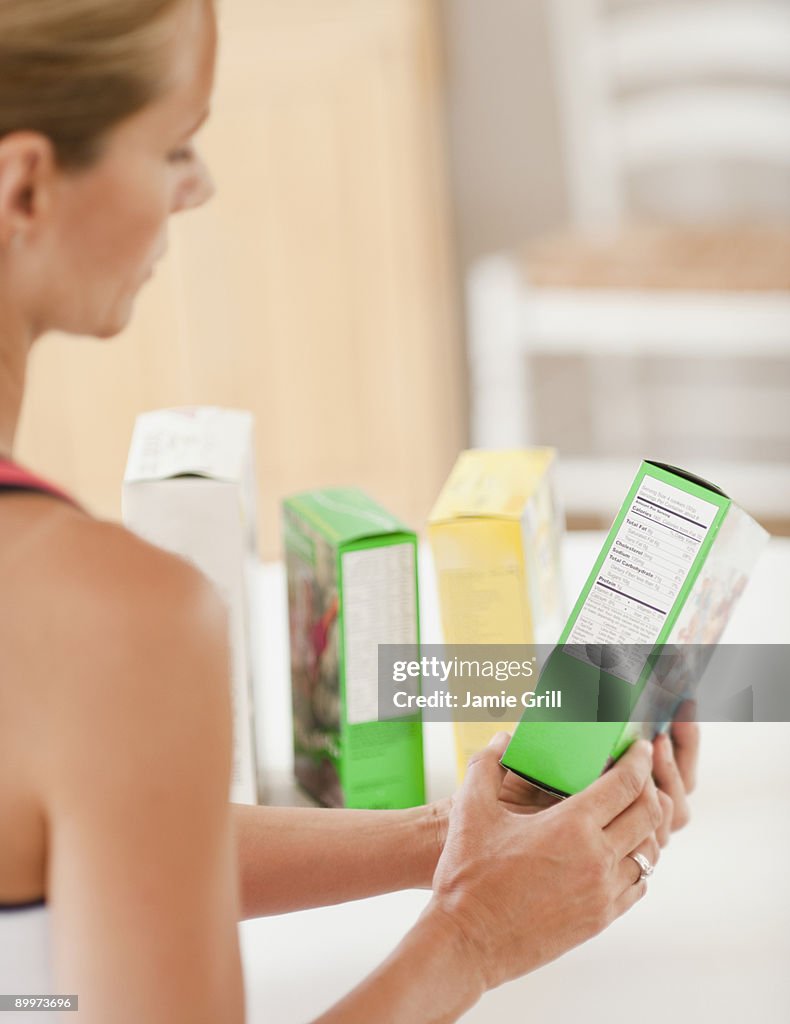 Woman checking nutrition label on box