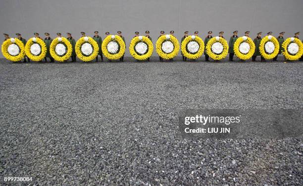 Chinese paramilitary soldiers line up as they hold wreaths for the rehearsal of a ceremony for the 70th anniversary of the Nanjing Massacre at the...