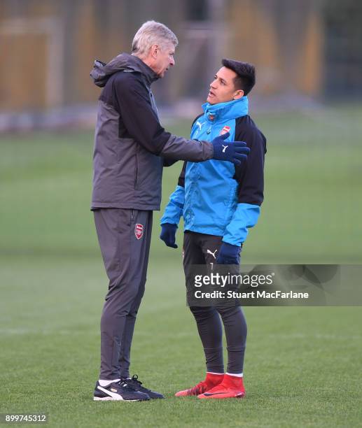Arsenal manager Arsene Wenger talks to Alexis Sanchez before a training session at London Colney on December 30, 2017 in St Albans, England.