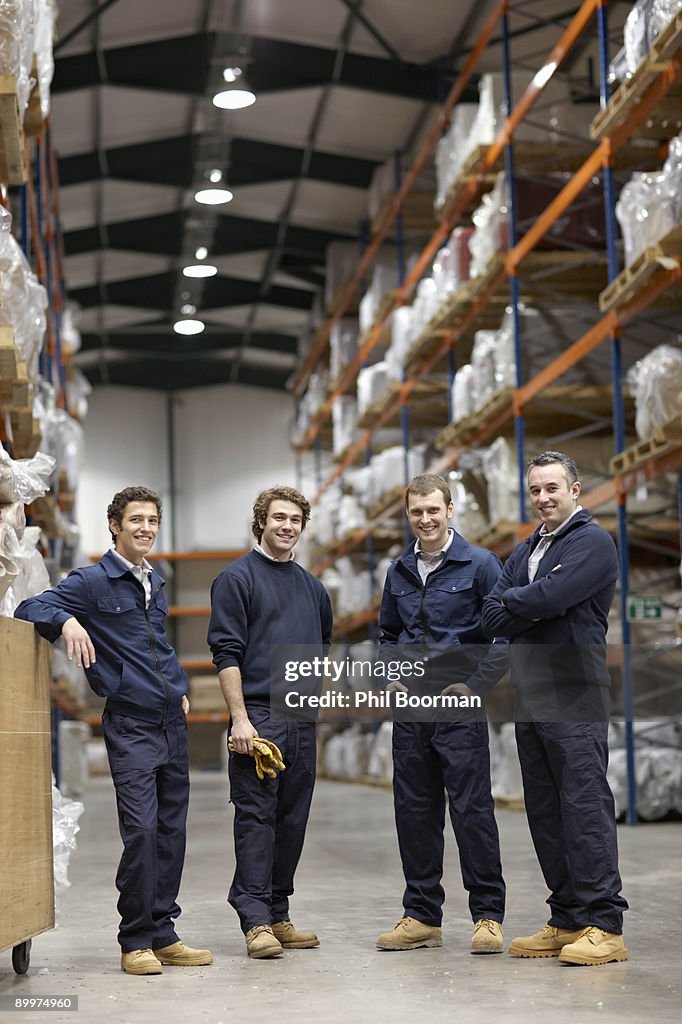 Workers in warehouse, smiling to camera