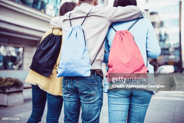 group of embraced students with backpacks walking after school - step sibling stock pictures, royalty-free photos & images