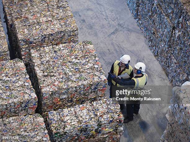 workers with bales of tin cans - wiederverwertungsanlage stock-fotos und bilder