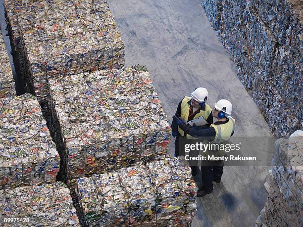 workers with bales of tin cans - vestido metalizado imagens e fotografias de stock