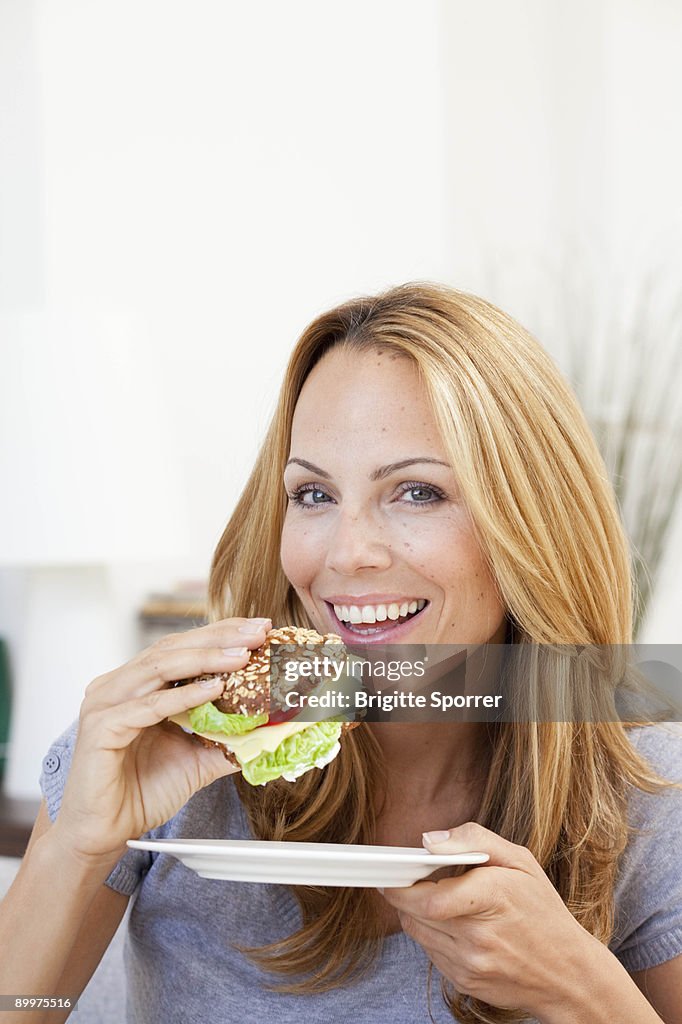 Young woman having sandwich