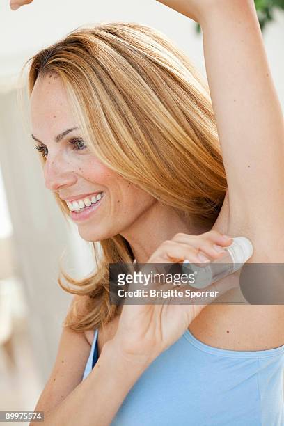 woman using roll-on deodorant - einzelne frau über 30 stock-fotos und bilder