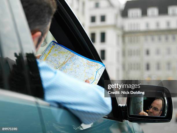 businessman map reading in car - technofobie stockfoto's en -beelden