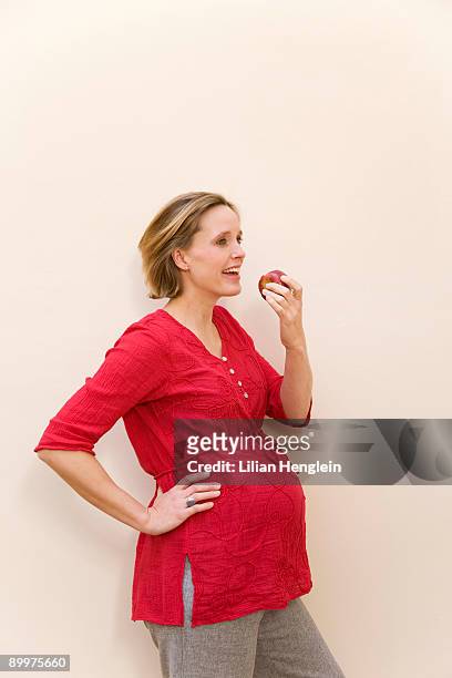 pregnant woman eating apple - frau apfel stock-fotos und bilder