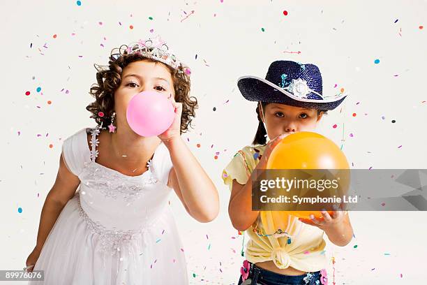party girls blowing balloons - child balloon studio photos et images de collection