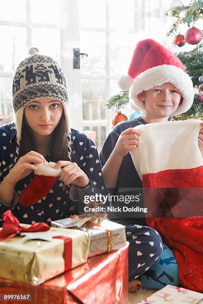 brother and sister with stockings - big xmas stocking stock pictures, royalty-free photos & images