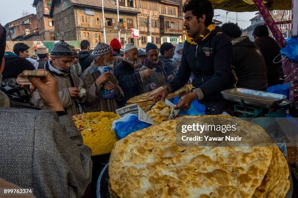 Kashmiri Muslims devotees buy local snacks from a vendor outside the Dastgeer Sahib shrine on the occasion of annual Urs of 11th century Sufi...