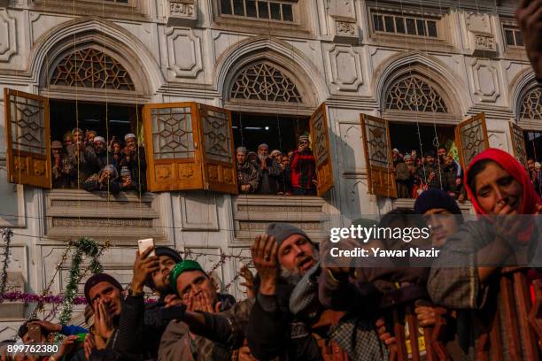 Kashmiri Muslims devotees pray while looking towards a cleric displaying the holy relic believed to be of Sufi Saint outside the Dastgeer Sahib...