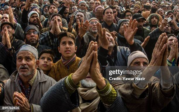 Kashmiri Muslims devotees pray while looking towards a cleric displaying the holy relic believed to be of Sufi Saint outside the Dastgeer Sahib...