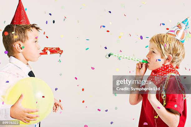 party boys blowing party blowers - child balloon studio photos et images de collection