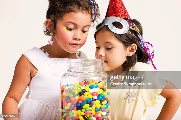 girls looking at sweet jar - jelly beans stock pictures, royalty-free photos & images