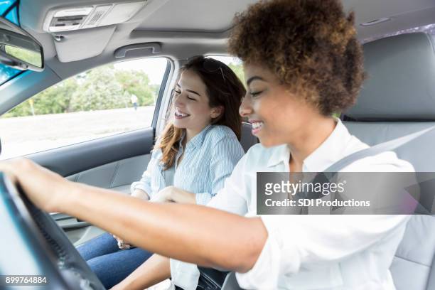 two female friends listen to radio during road trip - car listening to music imagens e fotografias de stock