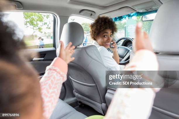 sonrisas de joven piloto mujer en niño en asiento trasero - seat perilous fotografías e imágenes de stock