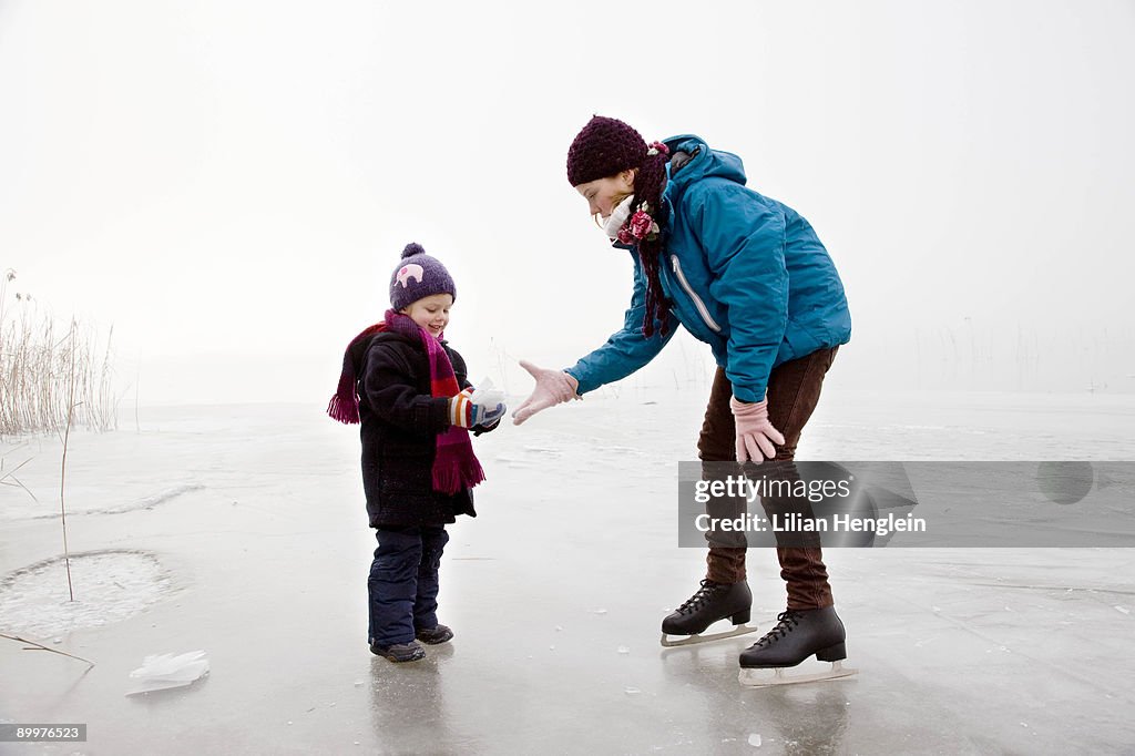 Girl and boy iceskating on frozen lake