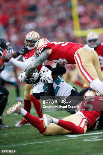 Cassius Marsh and Tyvis Powell of the San Francisco 49ers tackle T.J. Yeldon of the Jacksonville Jaguars during the game at Levi's Stadium on...