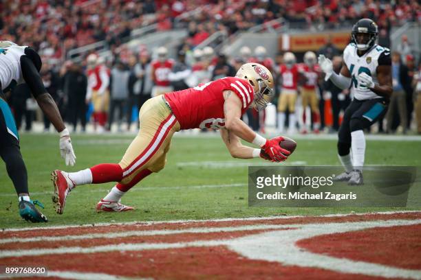 George Kittle of the San Francisco 49ers dives into the end zone on an 8-yard touchdown reception during the game against the Jacksonville Jaguars at...