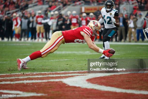 George Kittle of the San Francisco 49ers dives into the end zone on an 8-yard touchdown reception during the game against the Jacksonville Jaguars at...