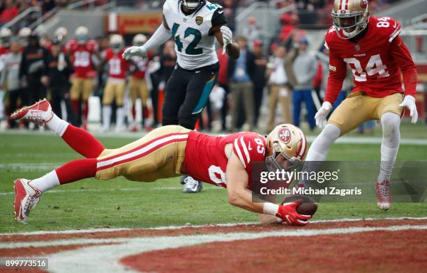 George Kittle of the San Francisco 49ers dives into the end zone on an 8-yard touchdown reception during the game against the Jacksonville Jaguars at...