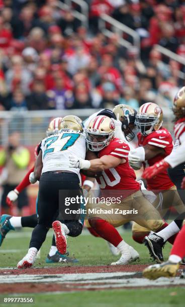 Dontae Johnson and Brock Coyle of the San Francisco 49ers tackle Leonard Fournette of the Jacksonville Jaguars during the game at Levi's Stadium on...