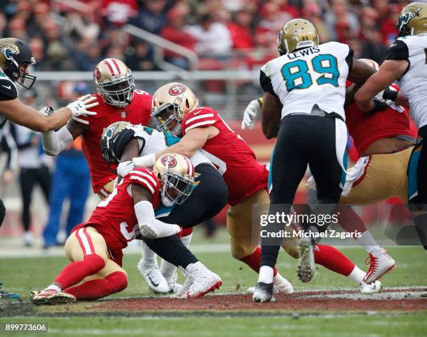 Dontae Johnson and Brock Coyle of the San Francisco 49ers tackle Leonard Fournette of the Jacksonville Jaguars during the game at Levi's Stadium on...