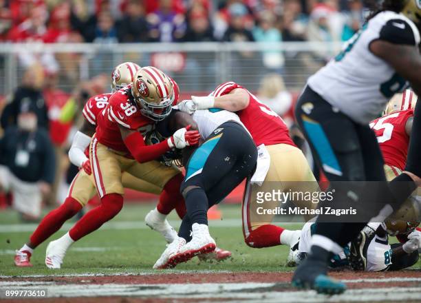 Dontae Johnson and Brock Coyle of the San Francisco 49ers tackle Leonard Fournette of the Jacksonville Jaguars during the game at Levi's Stadium on...