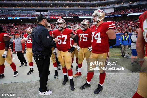 Offensive Line Coach John Benton of the San Francisco 49ers talks with Daniel Kilgore, Laken Tomlinson and Joe Staley on the sideline during the game...